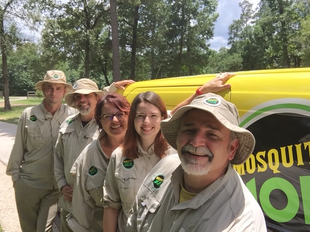 Team members of Mosquito Joe of S Brazos Valley standing in front of a transit