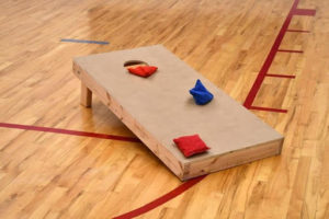 bag toss game setup on a wooden floor