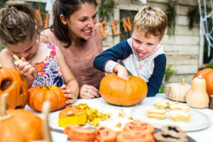 Family outdoors carving pumpkins